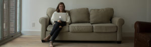 Meghan Easley sitting on couch on computer