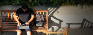working on a laptop on a bench